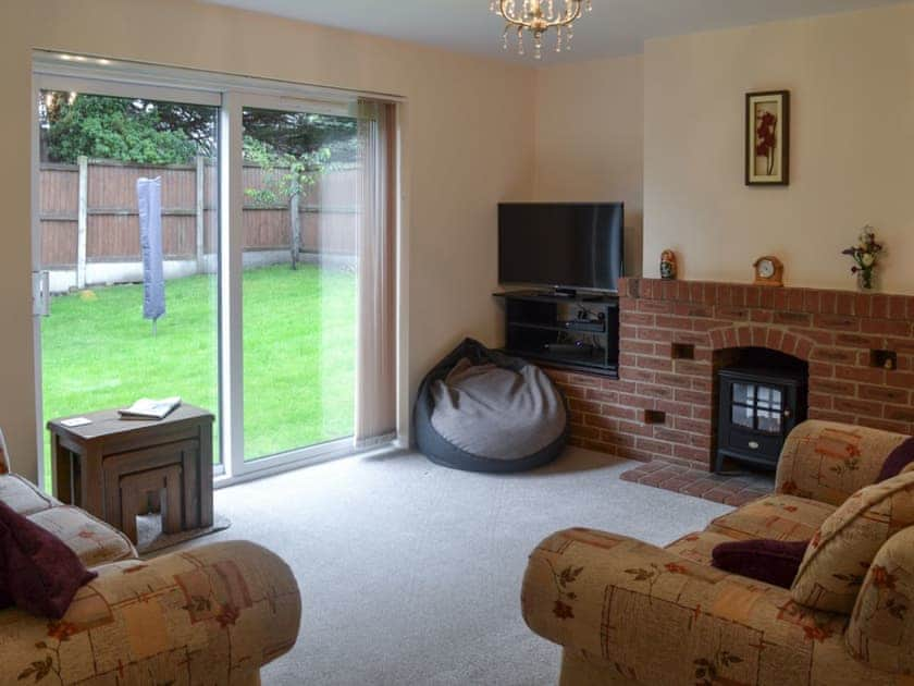 Living room with sliding patio doors leading to garden | Hideaway Cottage, Kingsgate, near Broadstairs