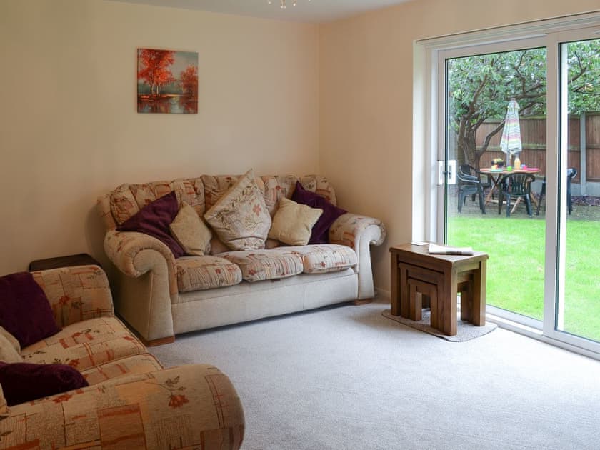 Living room with sliding patio doors leading to garden | Hideaway Cottage, Kingsgate, near Broadstairs