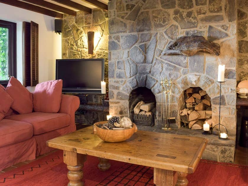 Living area with open fire & exposed stone fireplace | Sardis Cottage, near Kilgetty