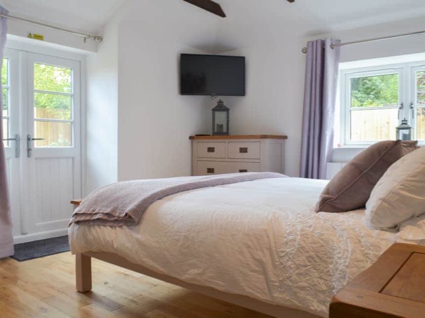 Cosy and comfortable kingsize double bedroom with double doors to garden | Bluebell Cottage, Over Stowey, near Taunton