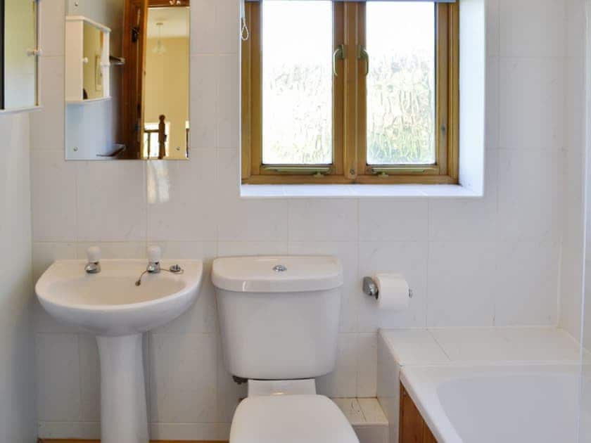 Tiled bathroom with shower over bath | Carters Cottage - The Old Timberyard, Puncknowle, near Dorchester