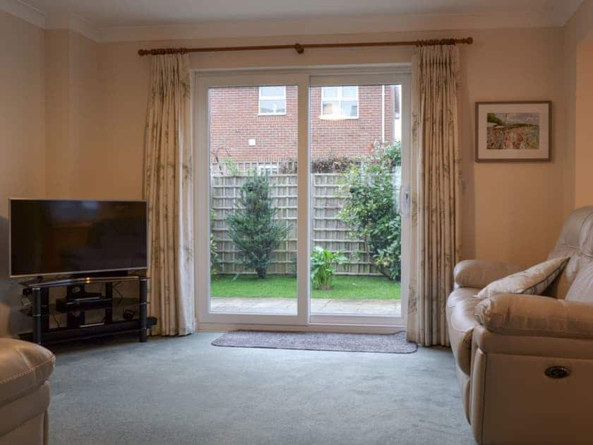 Living room with patio doors leading to garden | The Retreat, Ryde