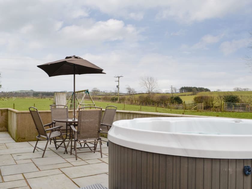 Enclosed patio area with hot tub | The Old Byre - West House Farm, Dearham, near Maryport
