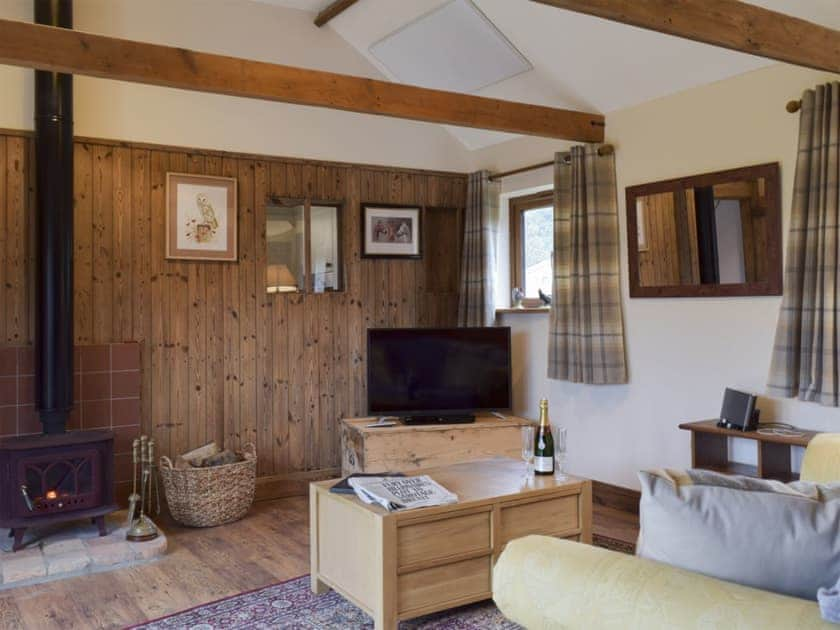 Cosy beamed living area with a wood burner  | Chick Hatch Barn, Carlton, near Saxmundham