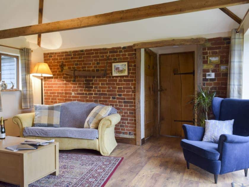 Cosy beamed living area with a wood burner  | Chick Hatch Barn, Carlton, near Saxmundham