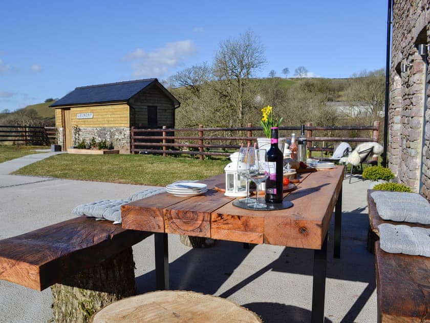 Patio with garden furniture, hot tub and BBQ | Maes Merlin, Llanddeusant, near Llangadog