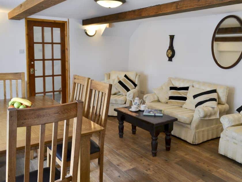 Dining room with oil Rayburn and beams | Knotty Corner Cottage, Fairy Cross, near Bideford