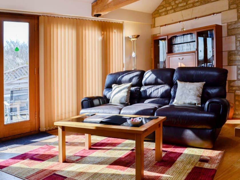 Sunny and bright living area with exposed stone wall | Stratton Mill, Cirencester
