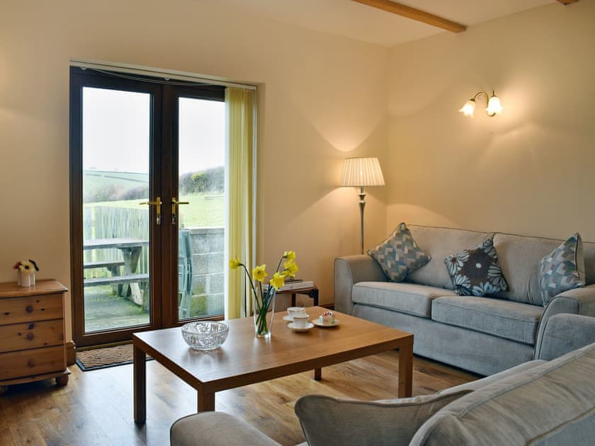 Welcoming living area with French doors leading to patio | Ty Nant, Llanon, near Aberaeron