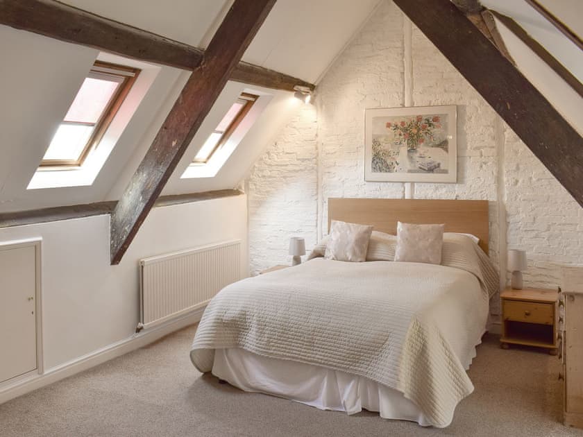 Upper floor double bedroom with exposed wooden beams | Cor Cottage, Whitby