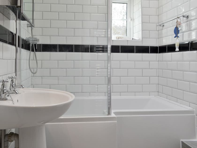 Family bathroom with shower over bath | Pebble Cottage, Holt