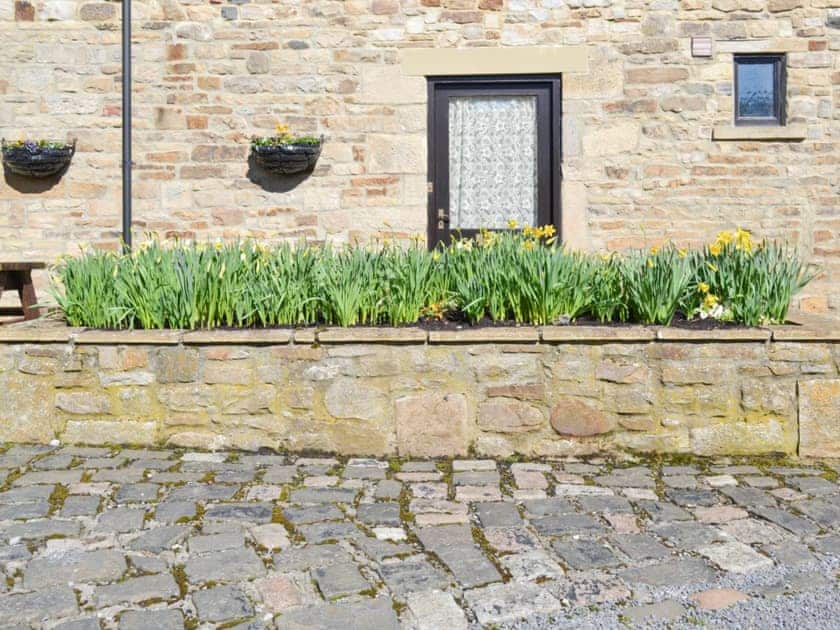Cheerful raised-bed floral display at entrance | The Stables - West Bridge End, Frosterley, near Bishop Auckland
