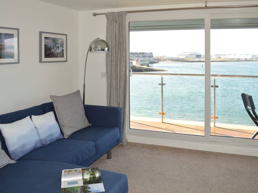 Spacious living room with patio door to balcony | Captain’s Suite - Crabbers’ Wharf, Portland