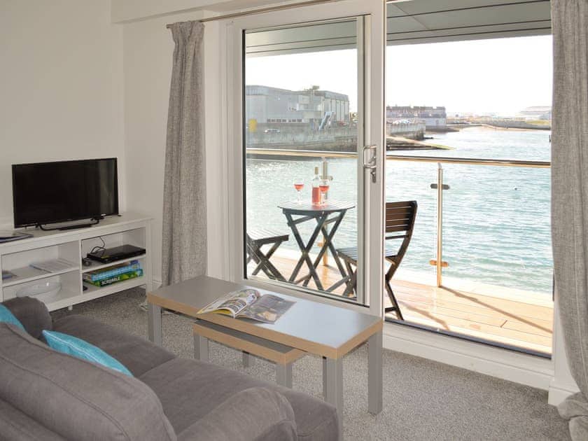 Living room with patio door to balcony | Purser’s Suite - Crabbers’ Wharf, Portland