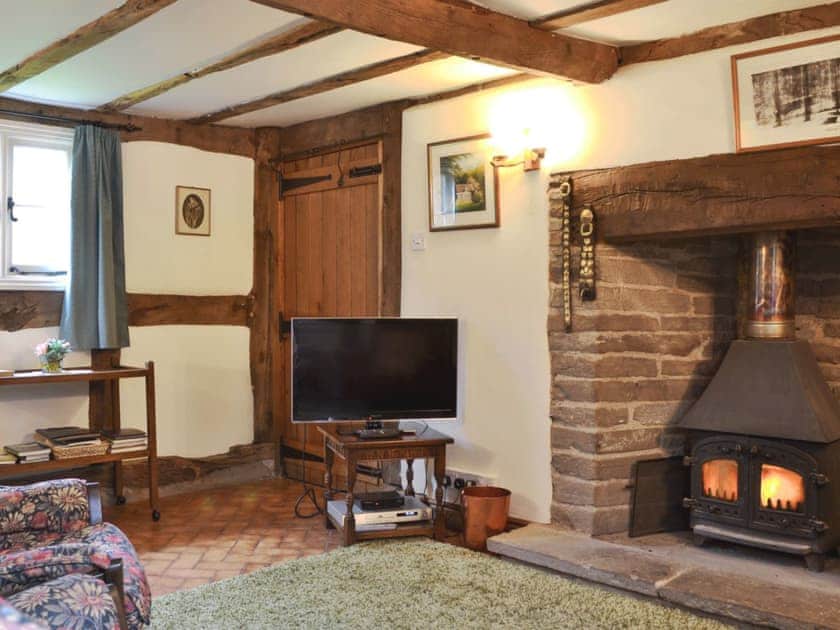 Impressive living room/dining room with beams and cosy woodburner | Hollywall Croft, Stoke Prior, near Leominster