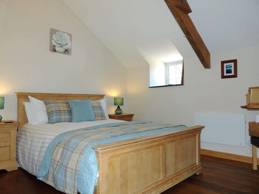 Impressive double bedroom with dual aspect wood burner | The Coach House Loft - Dolgoy Cottages, Llangrannog