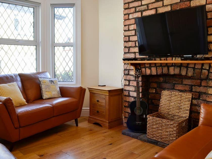 Wood-floored living room with feature fireplace | Llwynon Cottage, Llandudno