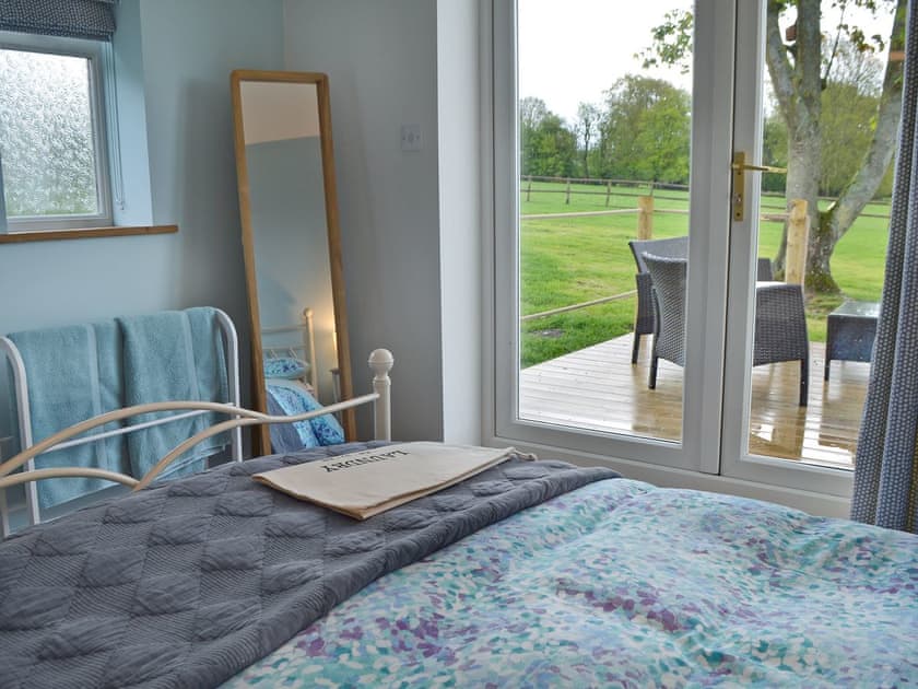 Bright and airy double bedroom with French doors leading to decked terrace | The Blue Loft, Playden, near Rye
