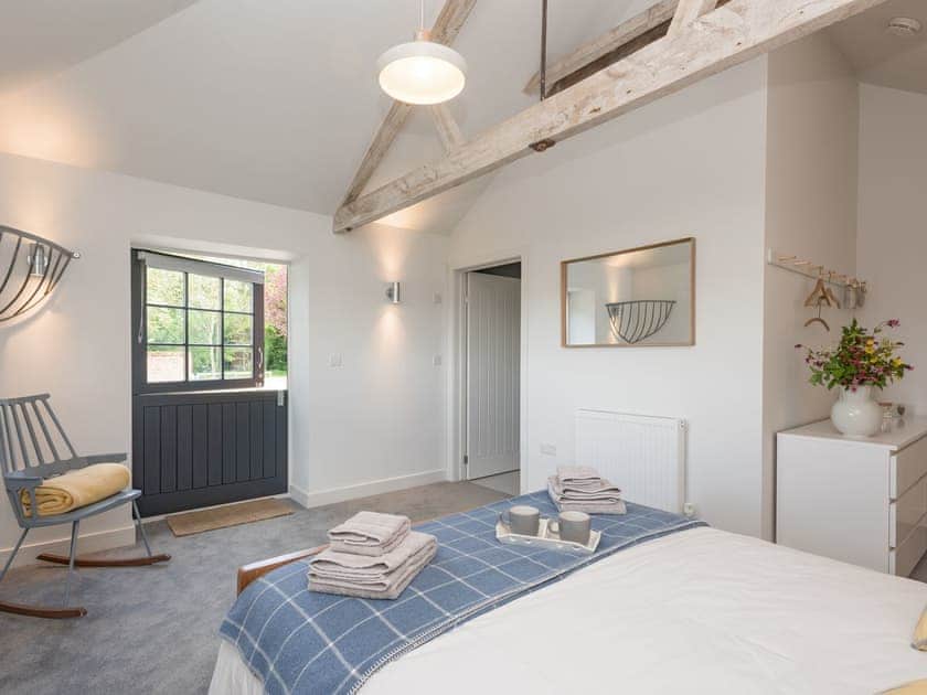 Light and airy en-suite double bedroom with door to enclosed patio  | The Cowshed, Reepham