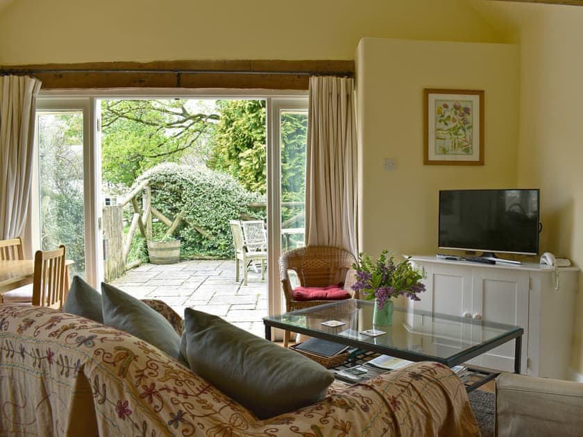 Welcoming living area with French doors to garden | The Old Forge, Lower Wraxall, near Dorchester