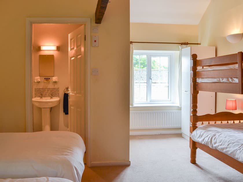Bedroom with twin beds and children’s bunk beds | Granary - Trimstone Manor Cottages, Trimstone, near Woolacombe