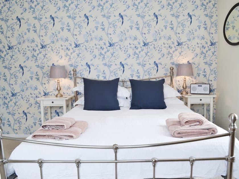 Pretty master bedroom with antique-style bed | Sea La Vie, Mundesley, near North Walsham