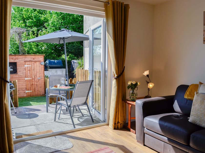French doors open from the living room to the paved patio and garden | Little Cottage, Wigtown