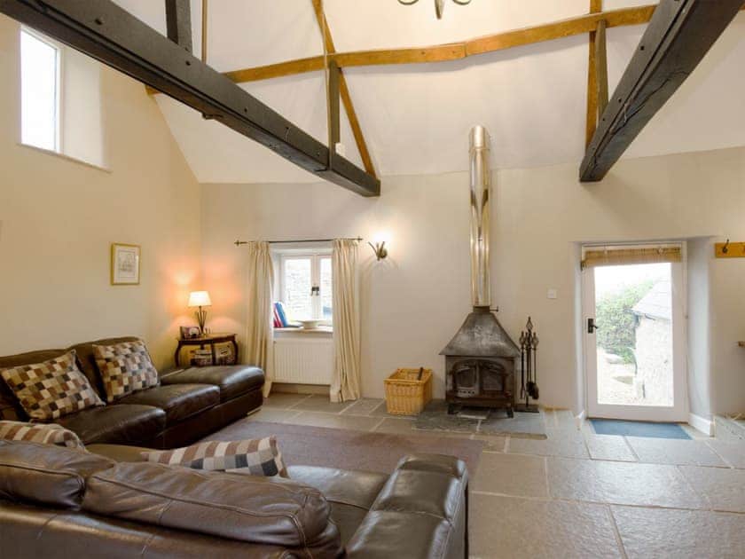 Spacious living room with wood burner and beamed ceilings | The Old Forge, Kingston, near Corfe Castle