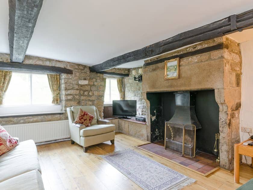 Living room with inglenook fireplace and open fire | Brookside Cottage, Beeley, near Chatsworth