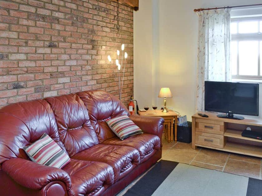 Lounge area with exposed-brick feature wall | Padgett Lodge - Filey Holiday Cottages, Filey