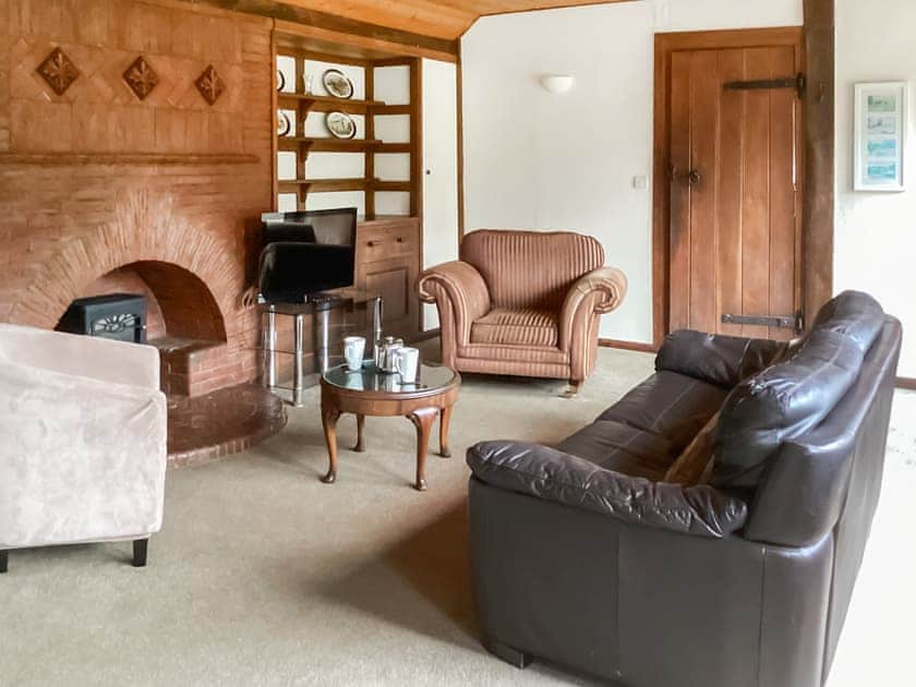 Delightful living room with feature brick fireplace | Summer House, St Asaph