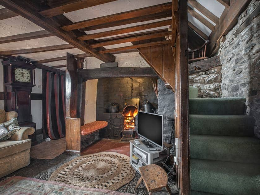 Living room with cobbled floor, open fire and many original features | Pen Copi, Trefeglwys, near Caersws