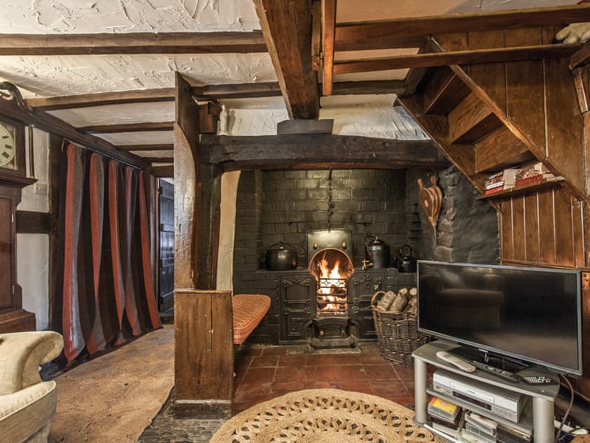 Living room with cobbled floor, open fire and many original features | Pen Copi, Trefeglwys, near Caersws