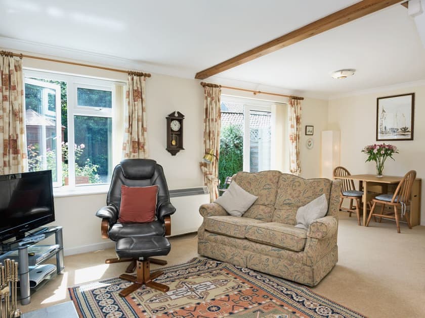 Spacious living/dining room with wood-burning stove and French doors | Camelot, Weybourne, near Holt