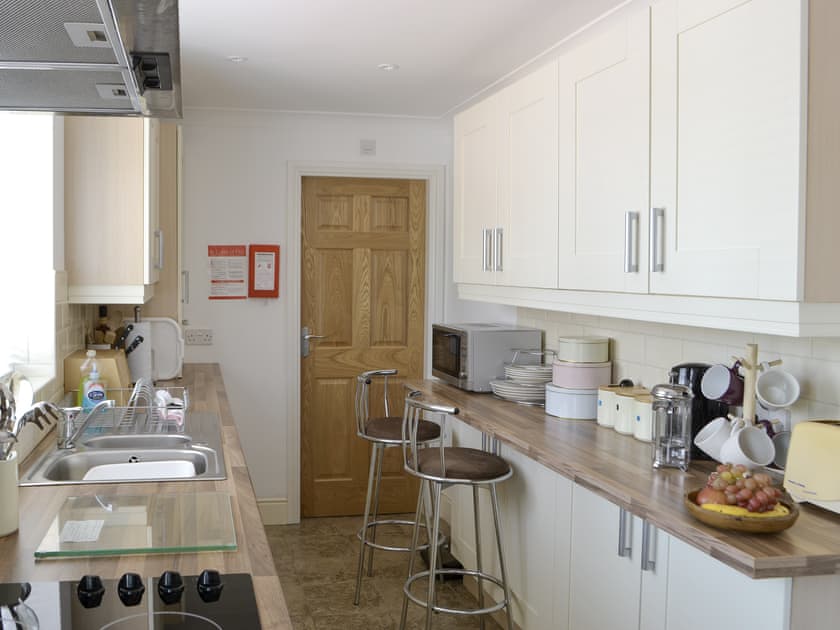 Galley-style kitchen with breakfast bar | Barkers Cottage, Ellington, near Druridge