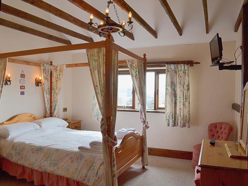 The romantic four poster bedroom has added charm thanks to exposed woodwork and sloping ceilings | Whitwell Farm CottagesAshley’s, Whitwell Farm, Colyford, near Seaton