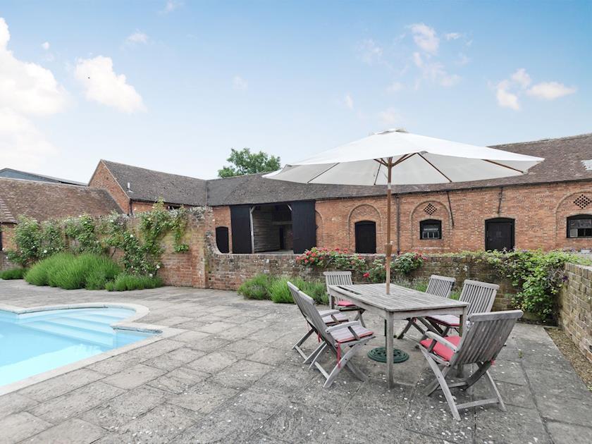 Exterior with pool & seating area | The Stables at Southfield House, Forthampton, near Tewkesbury