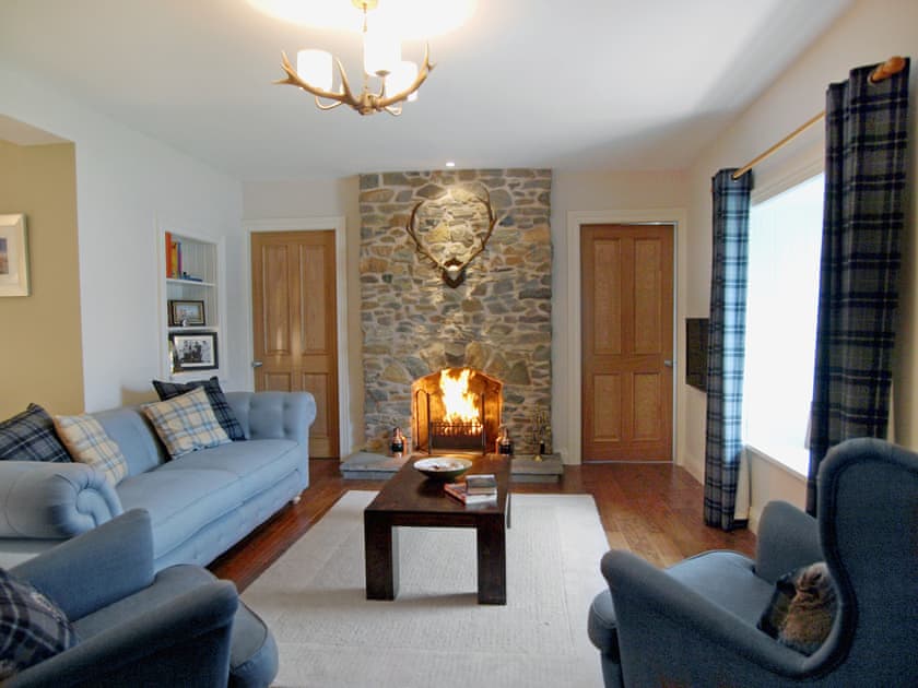 Living room with wood-burning stove and wooden floor | Ardbhan Croft, Oban, near Argyll
