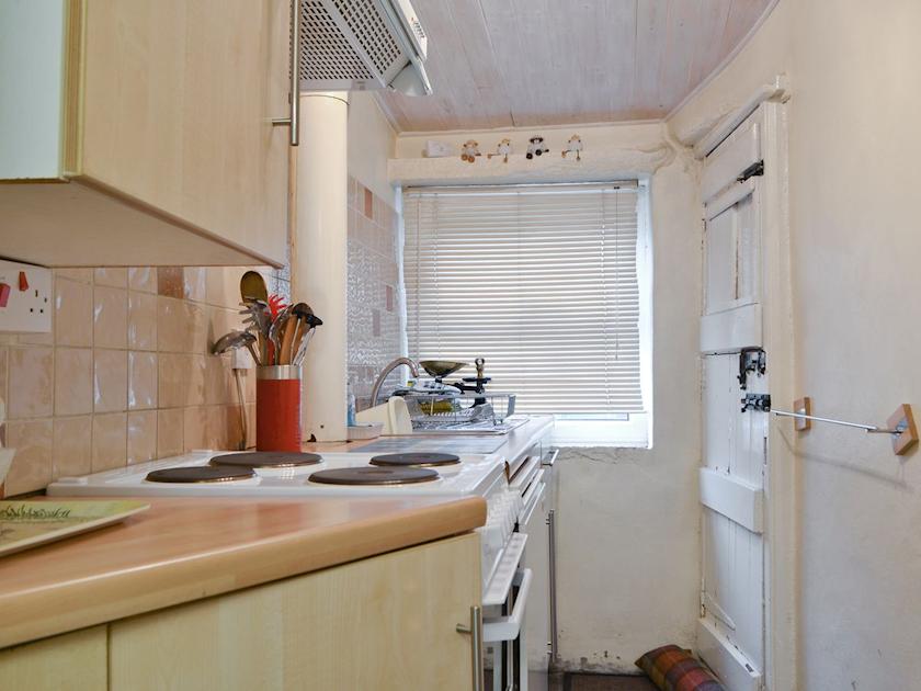 Galley style well-equipped kitchen with Yorkshire stone flagged floor | Cattlemarket Cottage, Hawes