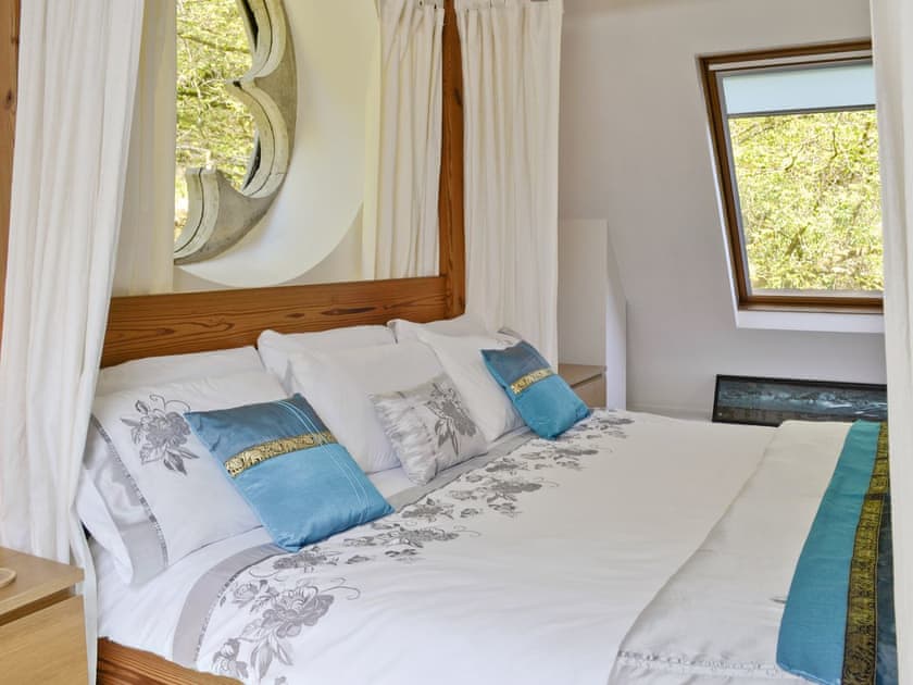 Four poster bed with character window | St John The Baptist Mission Church, Capel Curig