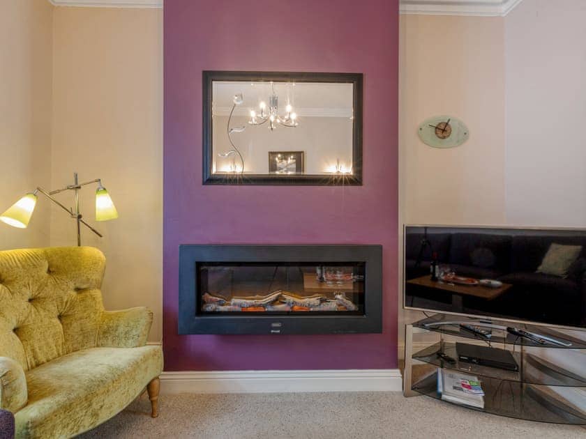 Cosy iving room leading through to kitchen | James’s Cottage, Keswick