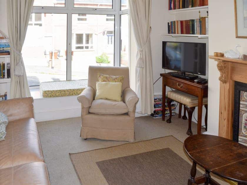 Sitting room with attractive pine fireplace with gas fire and window seats | Cranmere, Salcombe