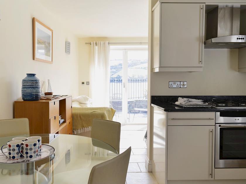 Fully fitted kitchen with glass dining table and chairs | Tuckers, Salcombe