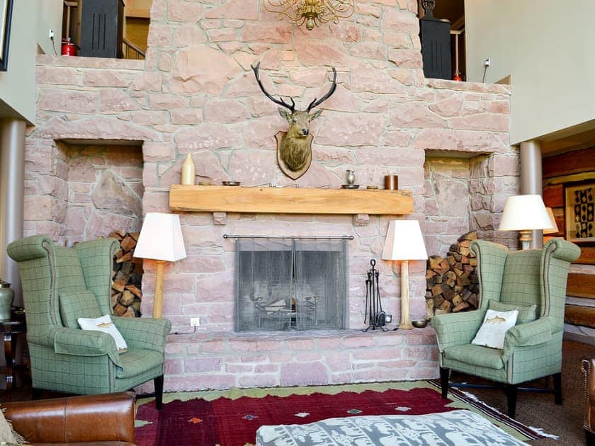 Large living room with vaulted ceiling and open fire | River Lodge - Ness Castle Estate, Inverness