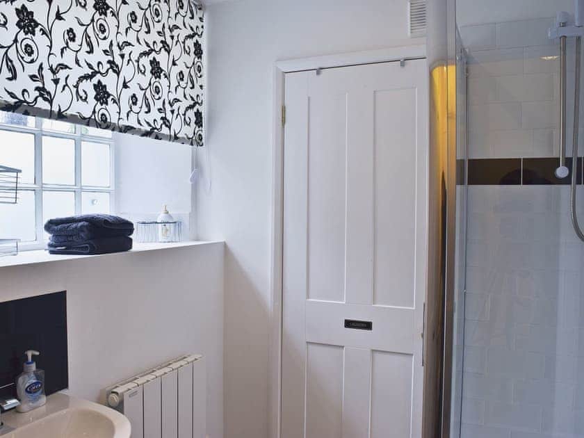 Shower room with WC, basin, shower and washer/dryer | Acorn Lodge Cottage, Keswick