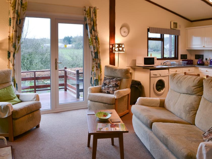 Living area with patio doors to elevated decked area | Catbank - Threapland Park, Moota, near Cockermouth