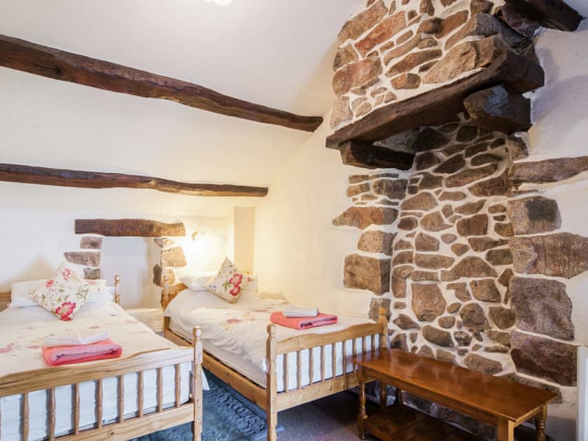 Twin bedroom with feature wall of exposed stonework | Wastwater Cottage - Bridge End Farm Cottages, Boot, near Eskdale