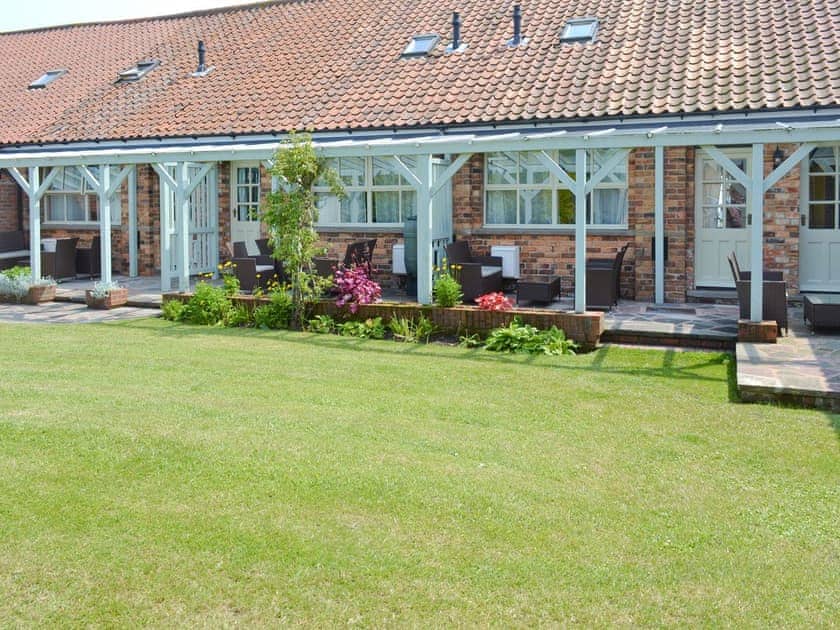 Rear lawned garden with covered patio | Lavender Cottage - Barmoor Farm Cottages, Scalby, near Scarborough