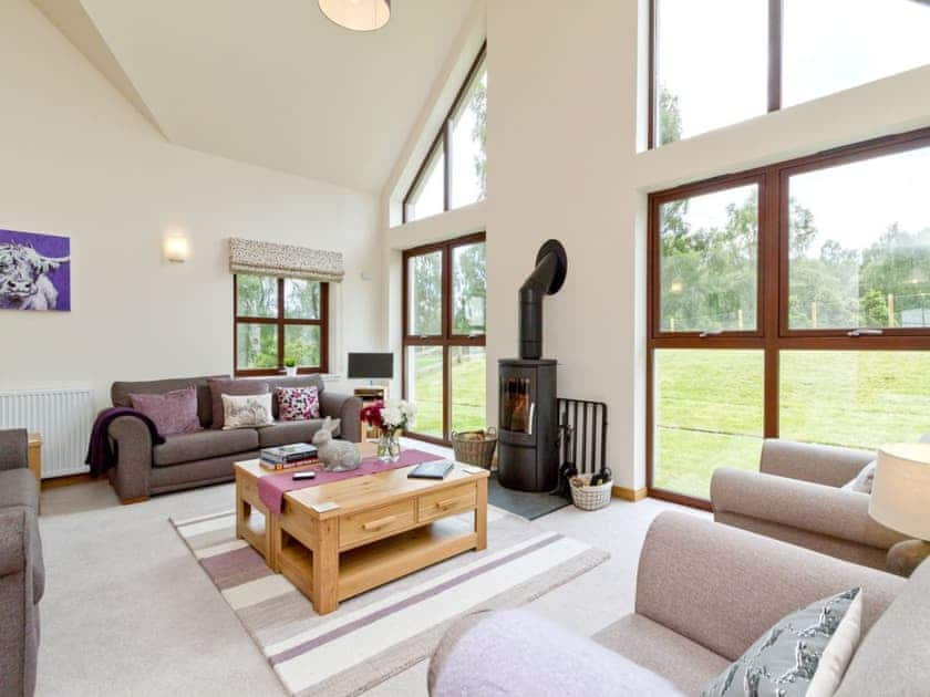 Beautiful living room with floor to ceiling windows and woodburner | Birch Corner, Aviemore