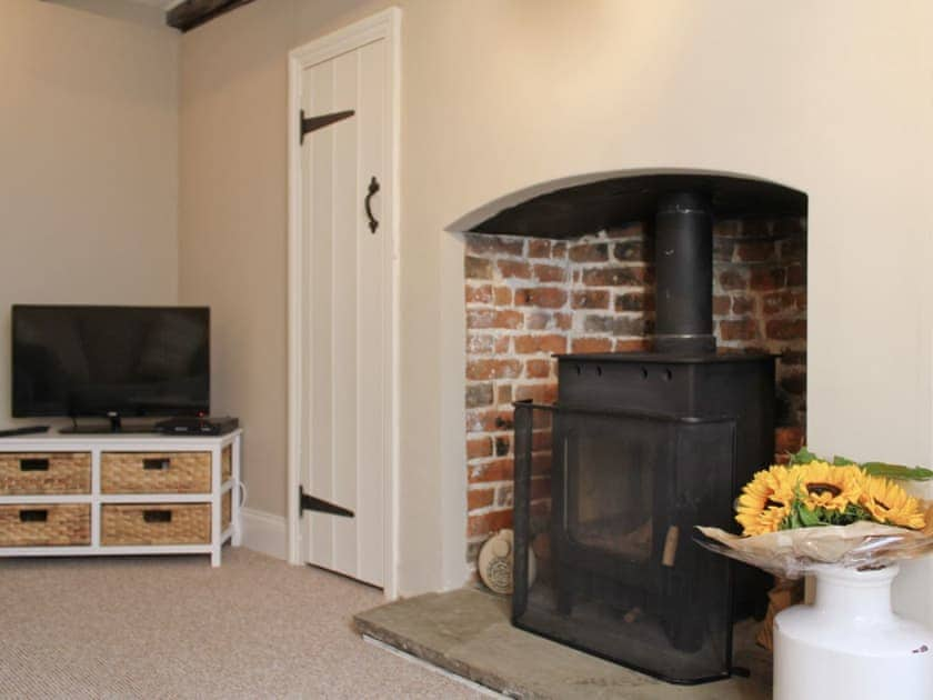 Living room with wood burning stove set in a inglenook fireplace | Anchor Cottage, Deal